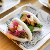 Pan bao de chipirón enharinado, rúcula, cebolla encurtida, ali-oli cítrico y salsa mostaza y miel